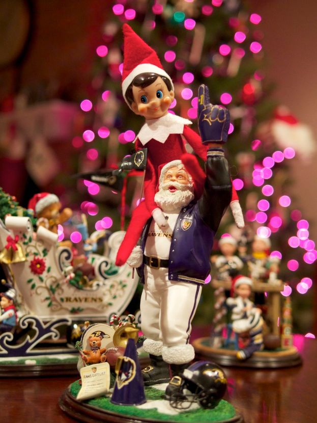 Spielfiguren vorne mit einem beleuchteten Weihnachtsbaum im Hintergrund.