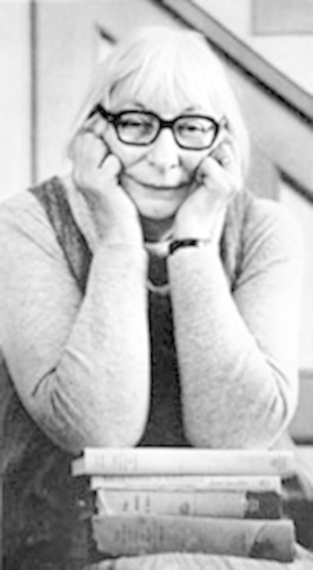 Ein Schwarz-Weiß-Bild einer Frau vor einer Sammlung von Büchern.