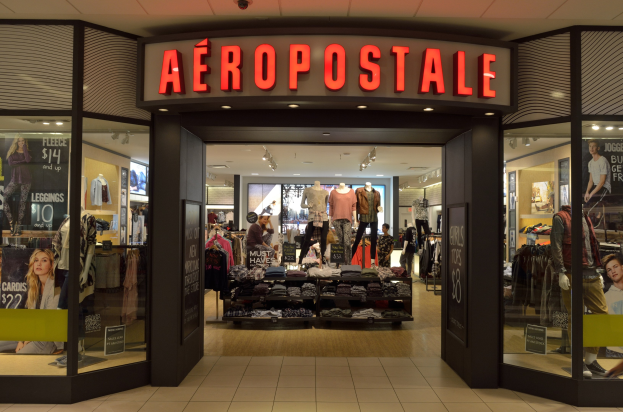 Aeropostale-Ladeninneres in einem Einkaufszentrum mit Kleiderstangen, Schaufensterpuppen in Kleidern, Texttafeln, Glaswänden und Beleuchtung, mit einer Anzeige, die den Abschluss im Juni anzeigt.
