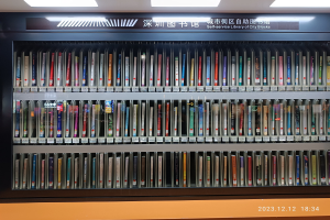 Eine gut beleuchtete Bibliothek mit hohen Bücherregalen voller Bücher, ein Textbrett und ein Wasserzeichen unten, das an eine Selbstbedienungsbibliothek der Stadtblocks erinnert.