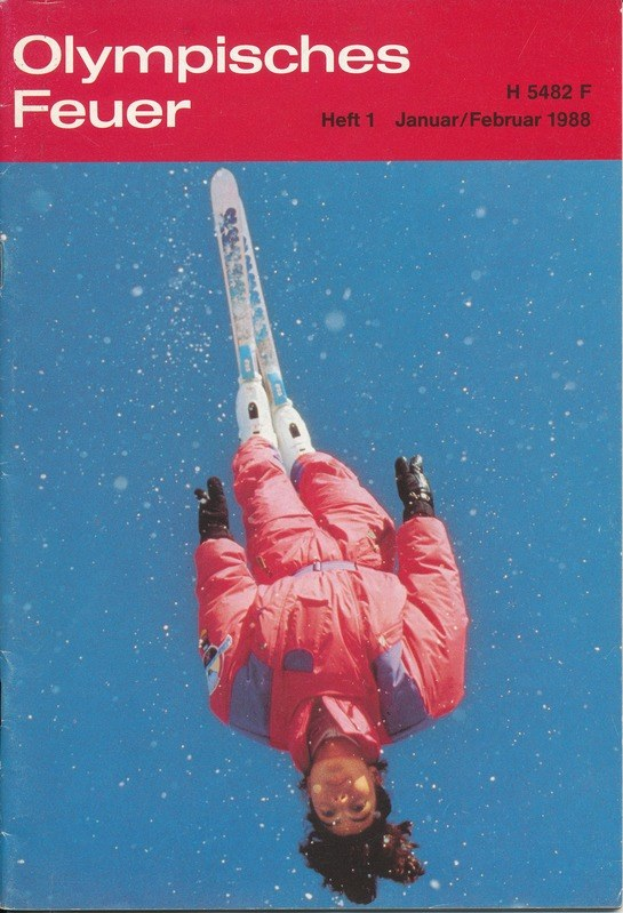 Titelbild von "Olympische Spiele Feuer - Heft 1 - Januar/Februar 1988" mit einem Skifahrer in der Luft, der eine Skiuniform mit entschlossener Miene trägt.