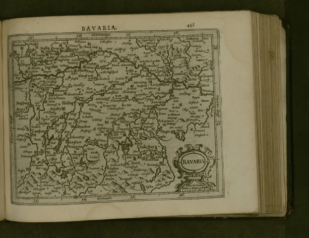 Ein aufgeschlagenes Buch mit einer detaillierten Karte von Bayern, auf der Städte und Ortschaften beschriftet sind, begleitet von erklärendem Text.