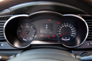 Ein Close-up-Bild des Armaturenbretts eines Autos mit verschiedenen Anzeigen und einem kleinen Bild eines Autos auf dem Bildschirm.