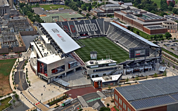 Luftaufnahme des Audi Field, Heimat des Atlanta United Football Club, umgeben von Stadtgebäuden, Bäumen, Straßen, Fahrzeugen und Gras.