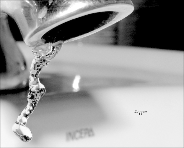 Ein Wasserhahn mit fließendem Wasser, mit einem unscharfen Wasserzeichen in der Mitte des Bildes.