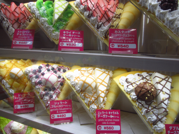 Vitrine voller verschiedener Eiscreme-Sorten mit Preisetiketten in unterschiedlichen Farben, Formen und Geschmacksrichtungen.