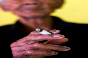 Eine Person hält eine Zigarette in der Hand.