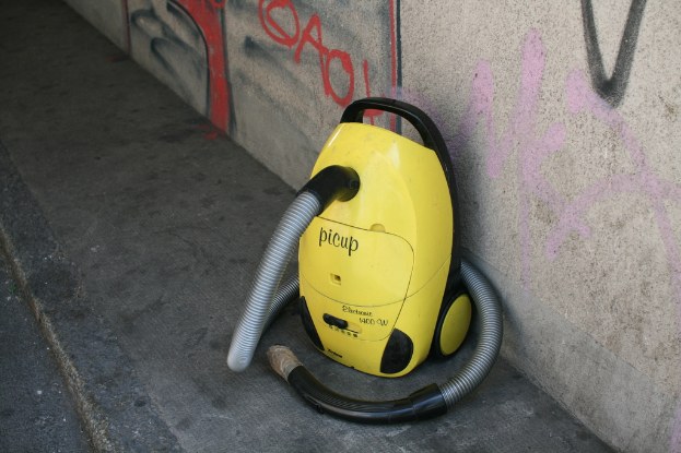 Eine Maschine ist in der Mitte des Bildes auf dem Boden positioniert, mit Graffiti an der Wand im Hintergrund.