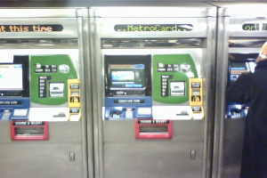 Automatische Ticket-Verkaufsmaschinen mit einer Person rechts daneben.