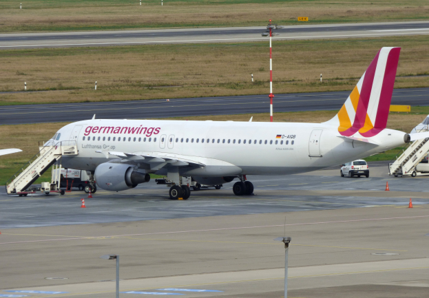 Ein Airbus A320-200 der Germanwings auf dem Frankfurt Airport mit Fahrzeugen, Verkehrskegeln, Mästen und Gras im Hintergrund.