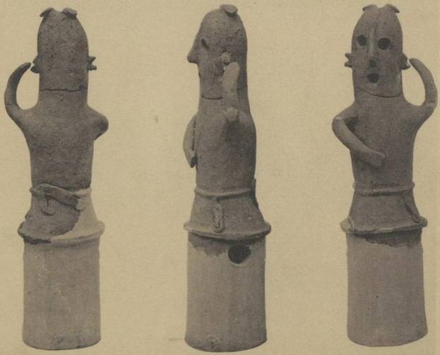 Drei Terrakottastatuen eines Mannes und einer Frau in traditioneller Kleidung, die eng beieinanderstehen und der Mann seinen Arm um die Schulter der Frau gelegt hat.