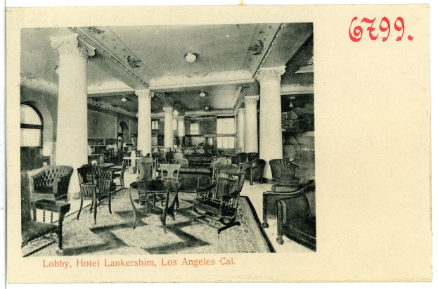 Ein Schwarz-Weiß-Foto einer Hotellobby in Los Angeles, das Stühle, Tische, Säulen, Deckenleuchten und Fenster auf der linken Seite zeigt, mit Text am unteren Rand des Bildes.