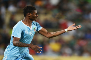 Fußballspieler in blauem Trikot feiert nach Torerfolg mit ausgebreiteten Armen