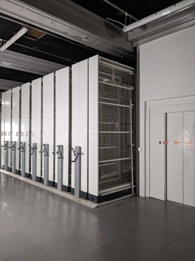 Ein großer Raum voller numerous Server, mit einem Boden, einer Wand auf der rechten Seite und einer Decke mit Leuchten oben, was auf ein Datenzentrum hinweist.