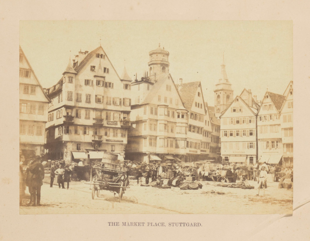 Altes Schwarz-Weiß-Foto eines belebten Marktplatzes in Stuttgart, Deutschland, mit mehrstöckigen Gebäuden, Fußgängern, Pferdewagen und verschiedenen Marktständen, mit handgeschriebener Text am unteren Rand.