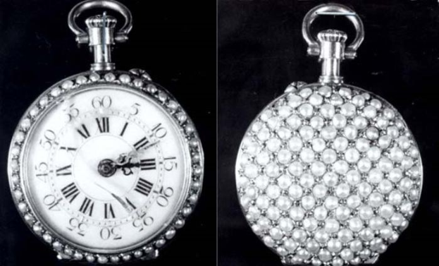 Eine silberne Taschenuhr mit Diamanten, die in einem runden Gehäuse mit römischen Ziffern eingelassen sind, vor einem schwarzen Hintergrund.