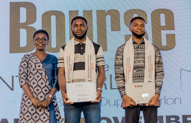 Drei Personen auf einer Bühne mit Urkunden, im Hintergrund ein Bildschirm mit der Aufschrift "Bounce Africa Awards 2019."