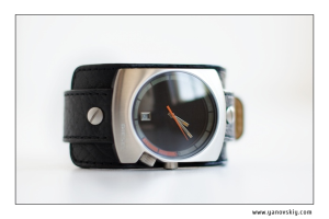 Ein bearbeitetes Bild mit einer Uhr, zwei Stellenangeboten und einem Lederriemen, mit Text in der rechten unteren Ecke.