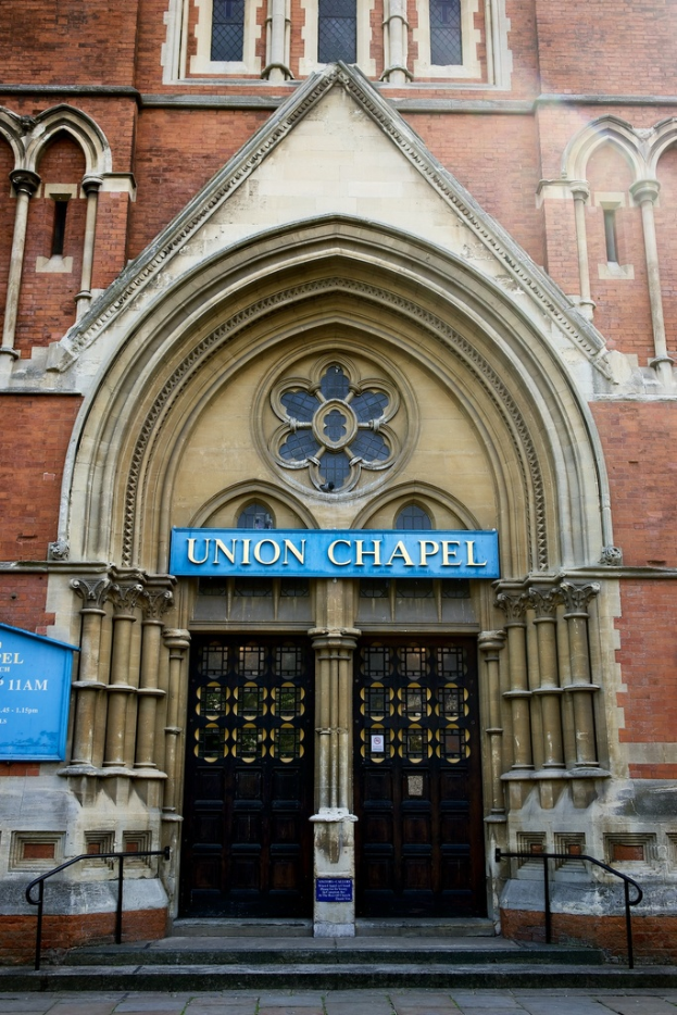 Eine große, historische Kirche in London mit zahlreichen Fenstern und zwei Türen am Eingang.