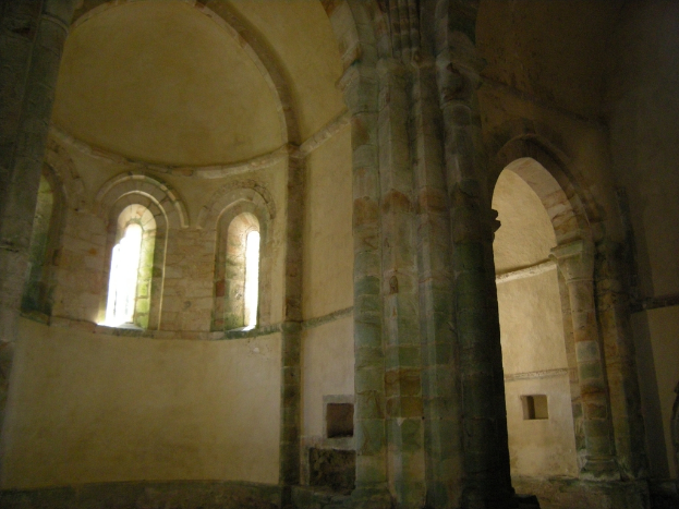 Das Innere einer Burg, das Steinpfeiler, Wände und Fenster auf der linken Seite zeigt.