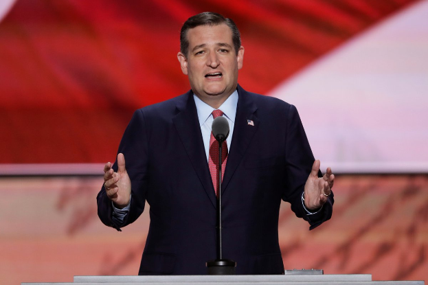 Ein Mann im Anzug und Krawatte steht an einem Podium mit einem Mikrofon und spricht vor einem Bildschirm, wahrscheinlich auf die Kündigung von Ted Cruz von der Republikanischen Nationalkonvention reagierend.