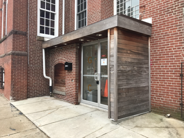 Ziegel-Feuerwache-Gebäude in Chicago mit einer Glastür und Fenstern, freiliegenden Rohren und einer Renovierungstafel an der Seite.