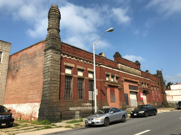 Altes Backsteingebäude mit seitlichem Schornstein, als ehemalige St. Louis-Feuerwache bezeichnet, umgeben von Straßeninfrastruktur und Fahrzeugen.