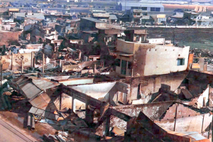 Mehrere Gebäude sind zu sehen, einige davon scheinen eingestürzt zu sein.